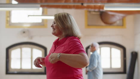 side view of happy caucasian female pensioner having dance class