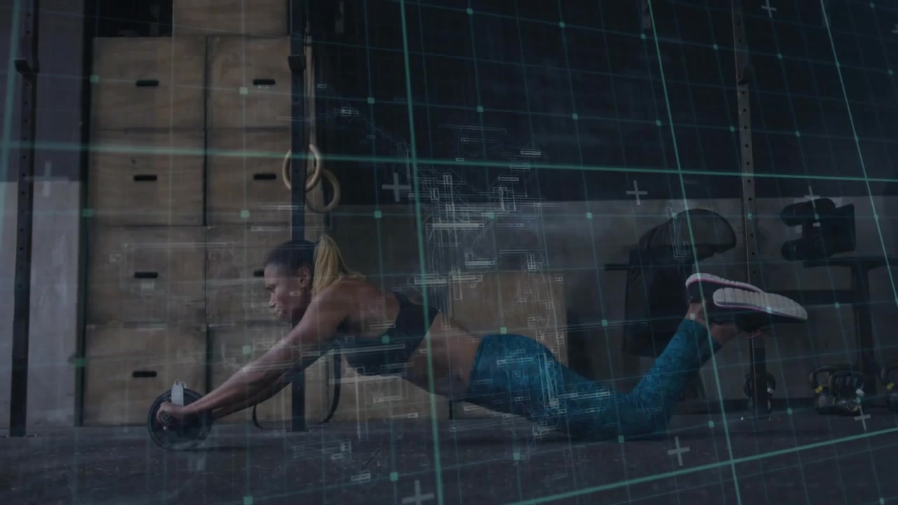 Woman pushing ab-wheel from knees in gym, extending torso for core while grid overlaying motion