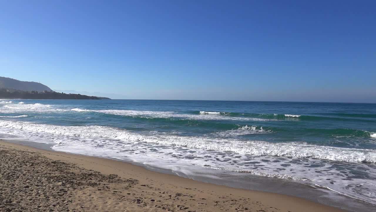 Spiaggia di sabbia deserta con mare e onde a Cefalù, Sicilia, Italia, vista dal Lungomare Giuseppe Giardina.