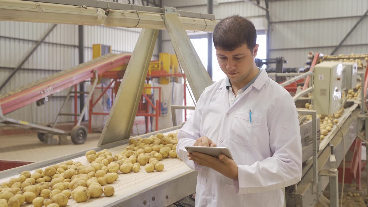 ingeniero agrícola trabajando con su tableta examina las patatas.