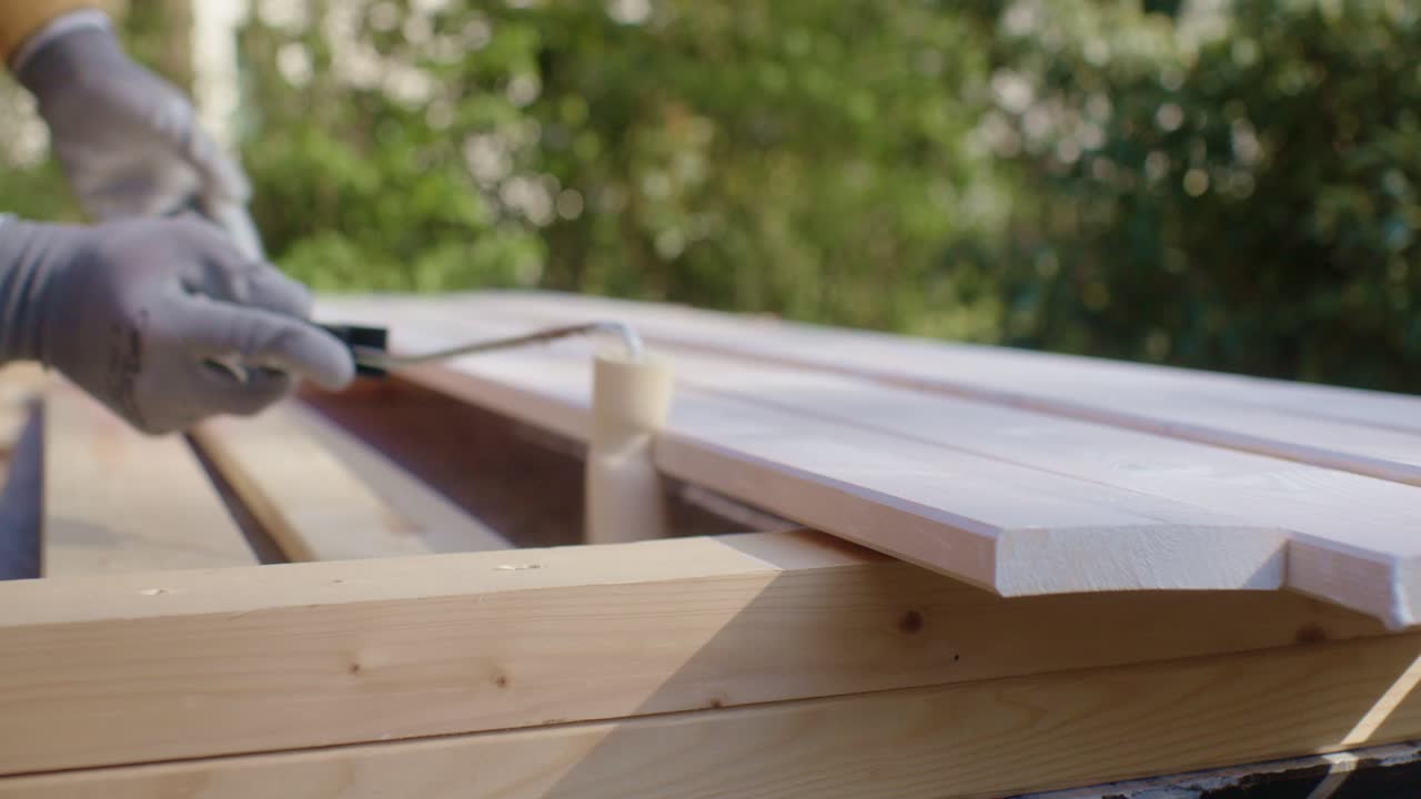 L'artigiano sta dipingendo il lato del legno