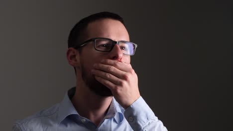 joven enfermo con gafas tose vigorosamente en la palma de su mano - cámara lenta
