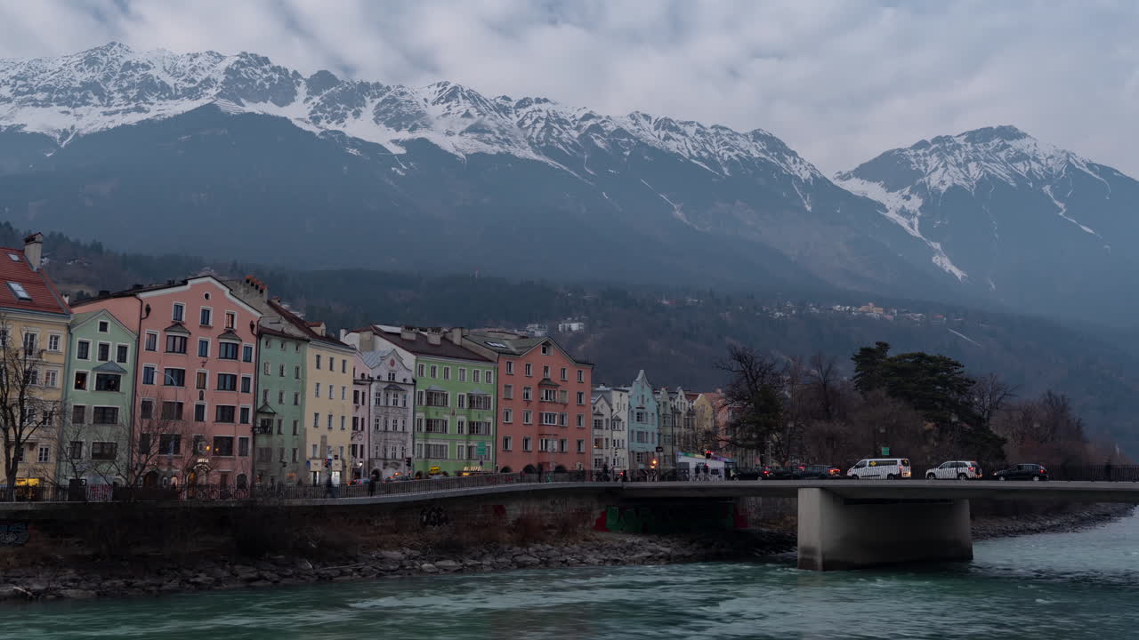 Zeitraffer, Innsbruck Österreich, Gebäude, Straßen- und Brückenverkehr unter Alpengipfeln an einem bewölkten Tag