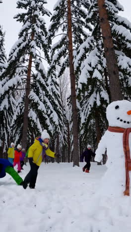 children playing with a snowman in a snowy winter forest