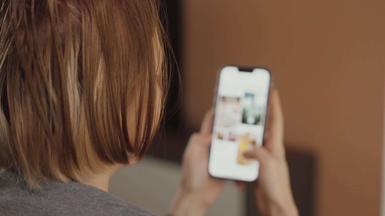A woman searches online for color palette and interior design inspiration on her smartphone — concept of home decoration, creativity, and modern lifestyle
