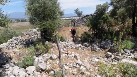 a hiker walking in the middle of old stone walls that are left from a broken down ancient building in southern turkey along the lycian way long-distance hiking trail