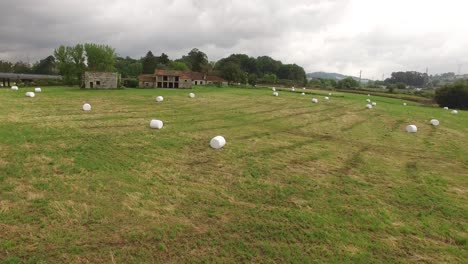 An-aerial-view-of-a-large-industrial-brown-field-with-many-hay-bales-in-4K