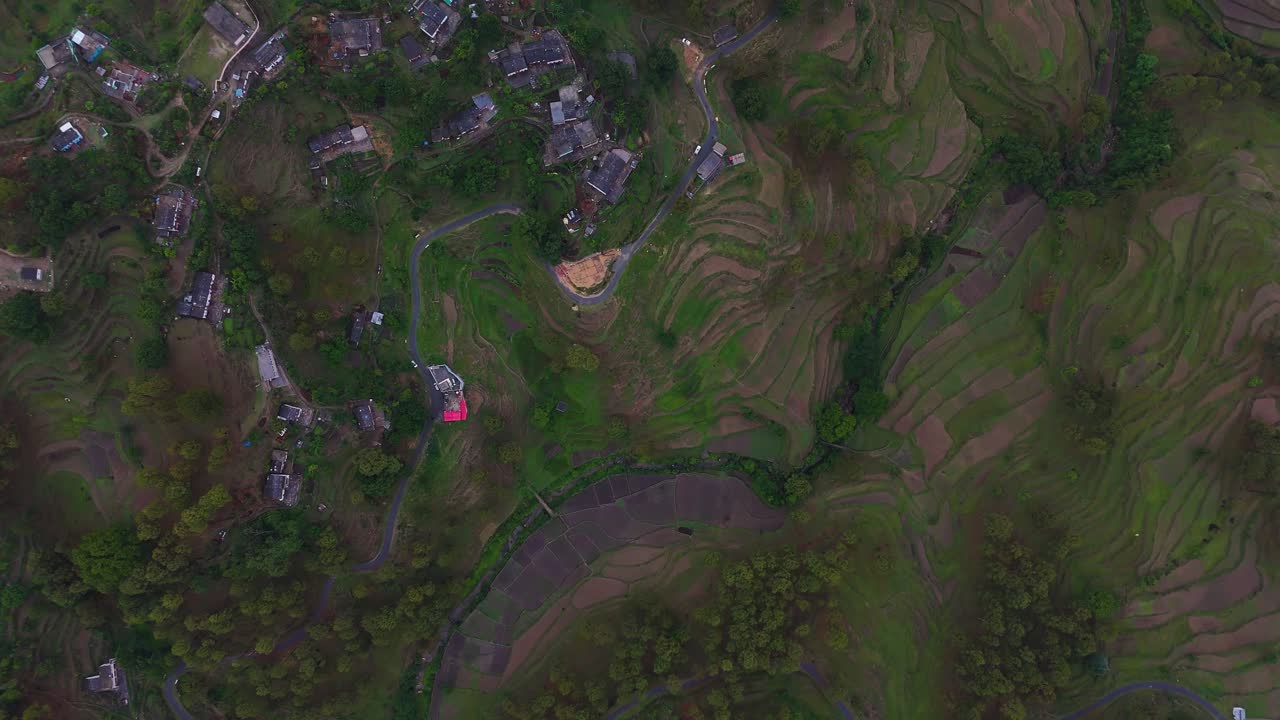 Aerial drone shot showcasing traditional homes scattered across a remote mountain village.