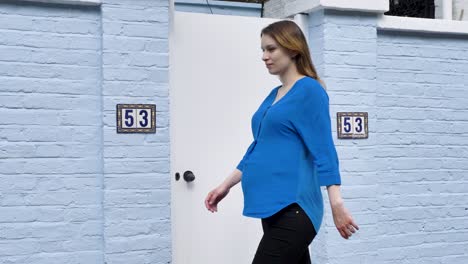 confident pregnant caucasian woman walking in a residential area of london