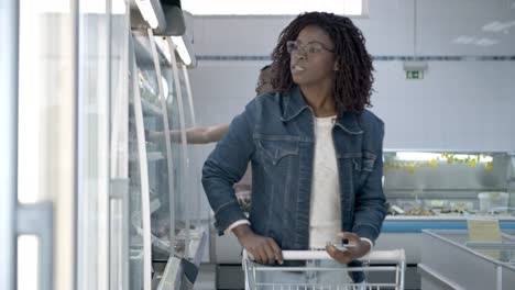 mujer negra concentrada comprando comida de acuerdo con la lista
