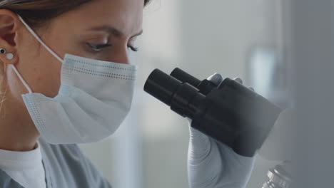 doctora usando el microscopio en el laboratorio.