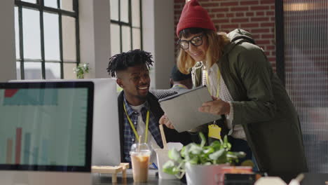 Junge-Geschäftsleute,-Die-Im-Startup-Büro-Arbeiten,-Kaukasische-Teamleiterin,-Die-Auf-Den-Bildschirm-Eines-Tablet-Computers-Zeigt-Und-Einem-Kollegen-Kreative-Ideen-Beim-Training,-Beim-Brainstorming-Und-Bei-Der-Diskussion-Von-Informationen-Zeigt