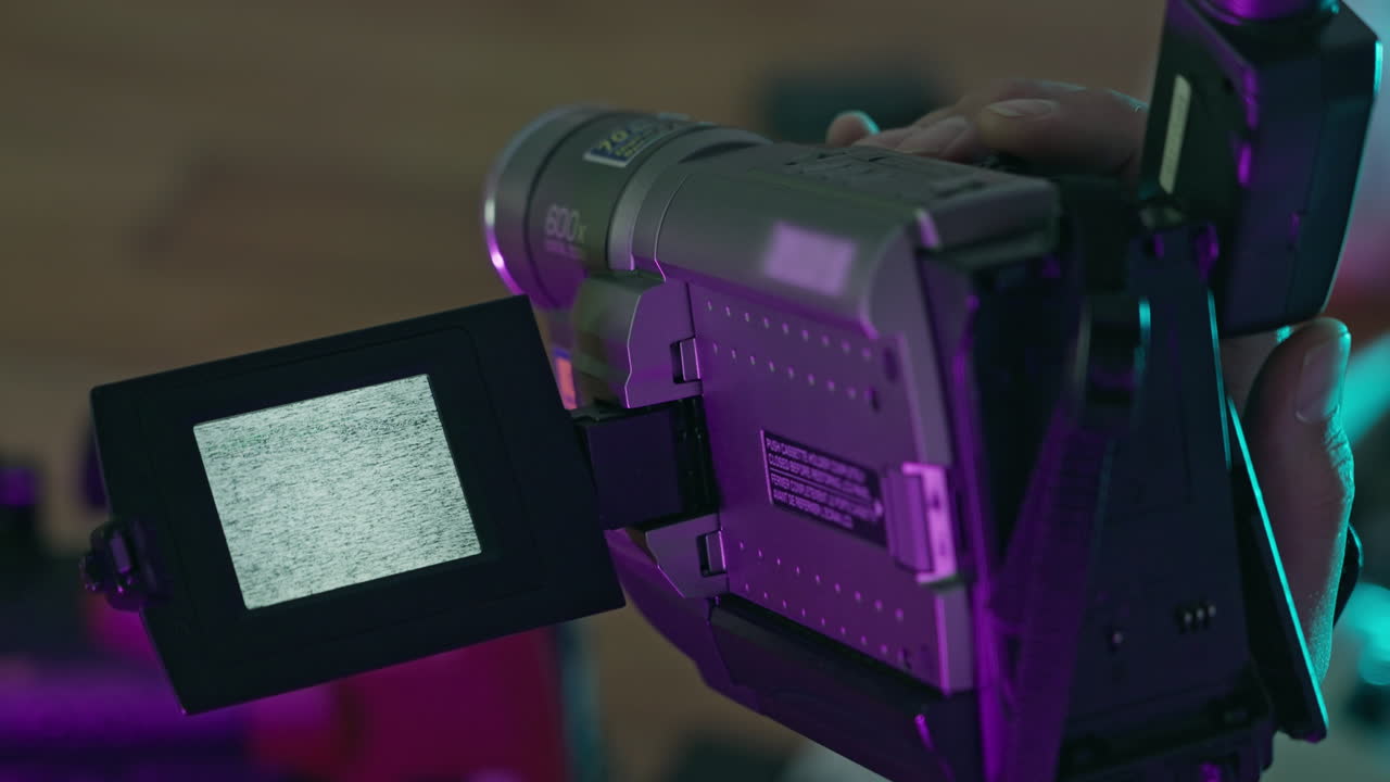Close-up of Vintage Camcorder with Static Screen in Neon Light