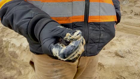 construction worker wearing nitrile gloves rubbing pipe lube - grease between fingers