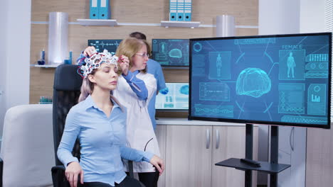 neurology female doctor making adjustments to brainwaves headset