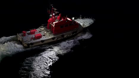 pilot boat pulls away from the ship and turns off searchlights