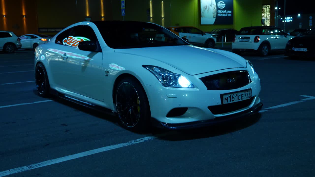 White Car in a Parking Lot at Night