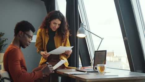 Multiethnic-Colleagues-Discussing-Documents-in-Office