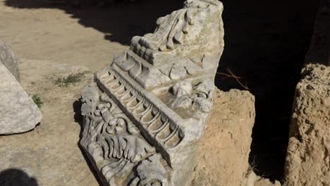 Ancient-Roman-carved-stone-detail-in-Carthage,-Tunisia,-under-clear-skies