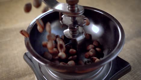 coffee beans fall in the old grinder. slow motion with rotation tracking shot.