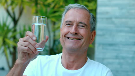 Retired-man-toasting-with-water-outside