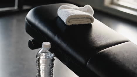 gym workout setup with dumbbell and water bottle