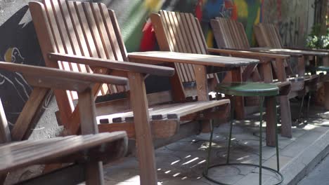 sillas de madera vacías en una acera de la ciudad