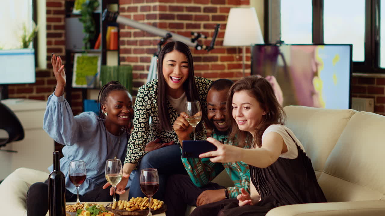 Joyful mates in modern home posing for photo with wine and champagne glasses, making gestures
