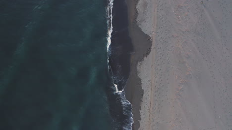 aerial view of black sand beach and ocean waves