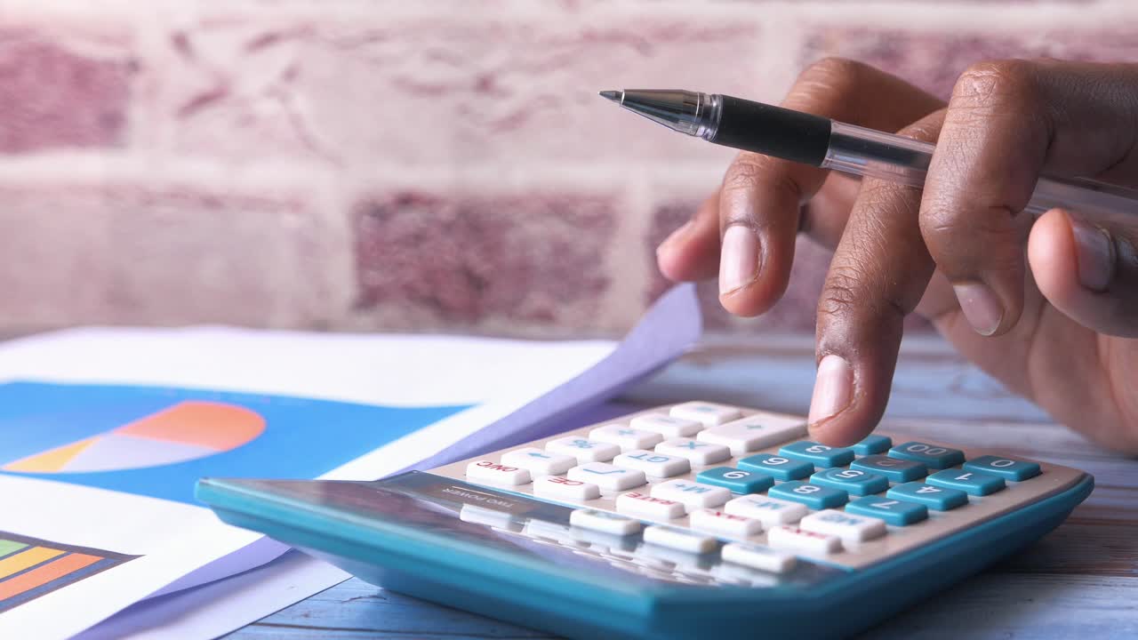 persona que utiliza calculadora y documentos financieros