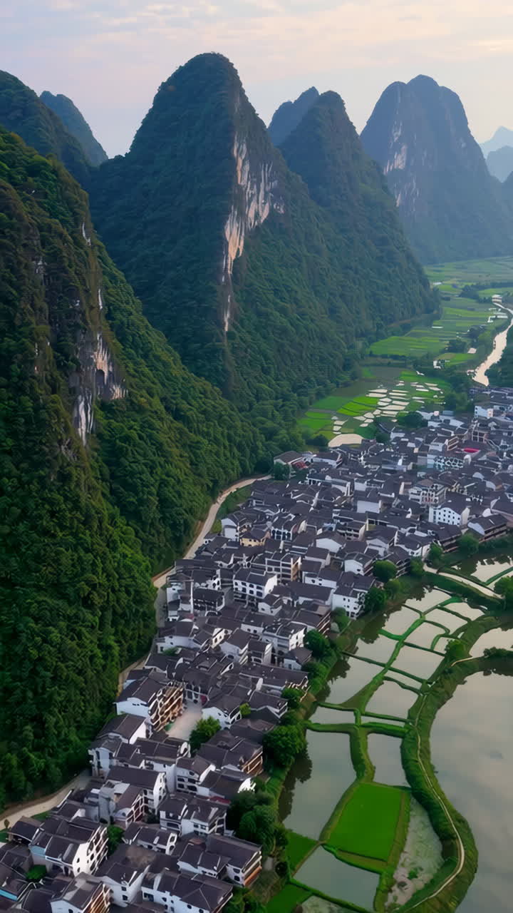 Aerial View of a Chinese Village Nestled in a Valley with Rice Paddies and Mountains