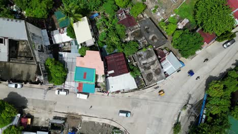 Top-down-aerial-rising-view-of-busy-three-way-intersection-in-southeast-asia-nieghborhood