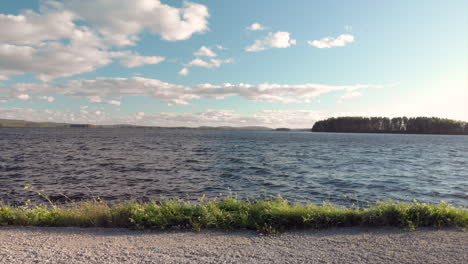 High waves on a lake next to a small road