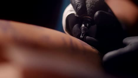 maestro del tatuaje tatuaje con tinta en la piel del cliente en el estudio