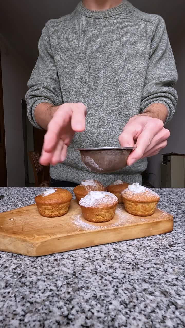 집에서 만든 컵케이크를 장식하기 위해 설탕 가루를 첨가하는 것