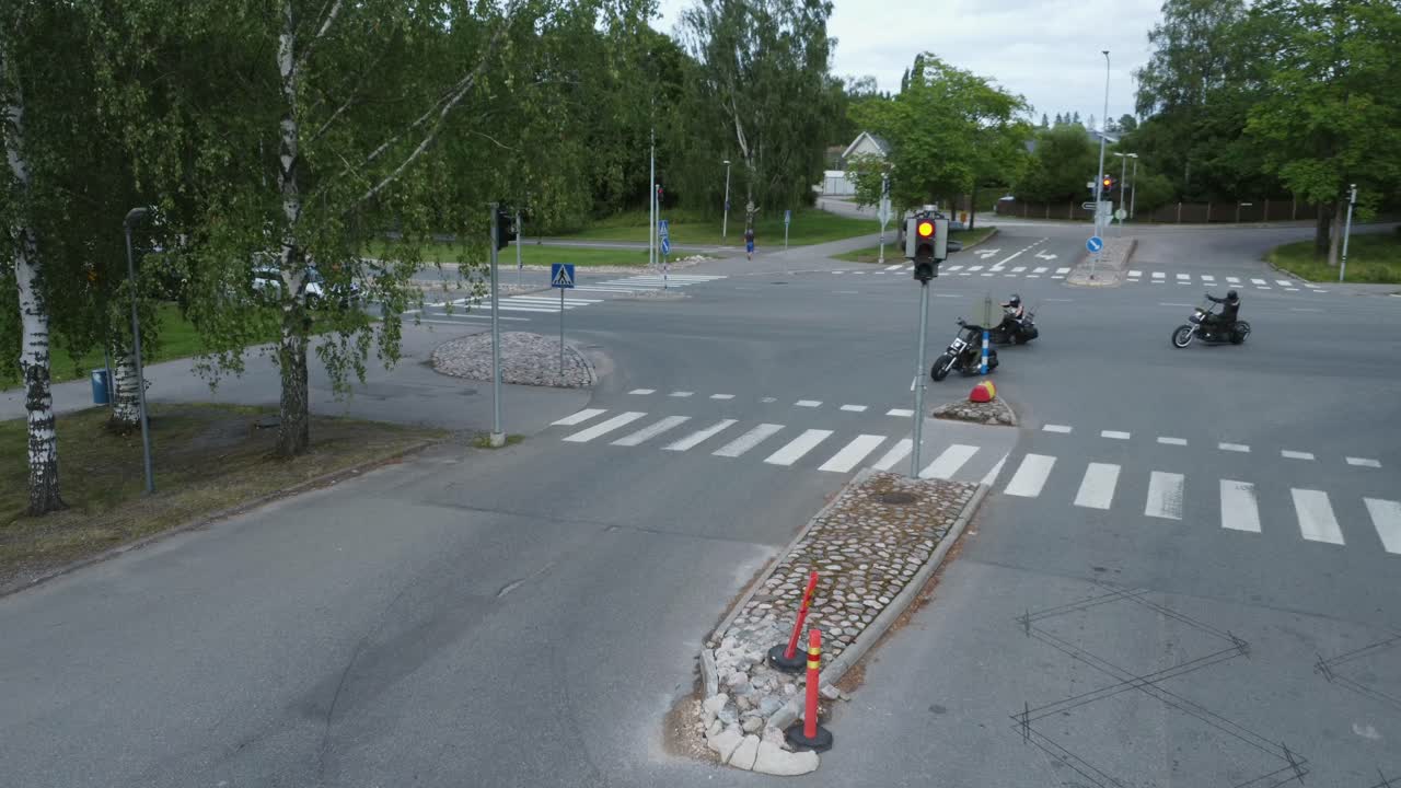 High angle view as bikers on custom motorcycles turn street corner