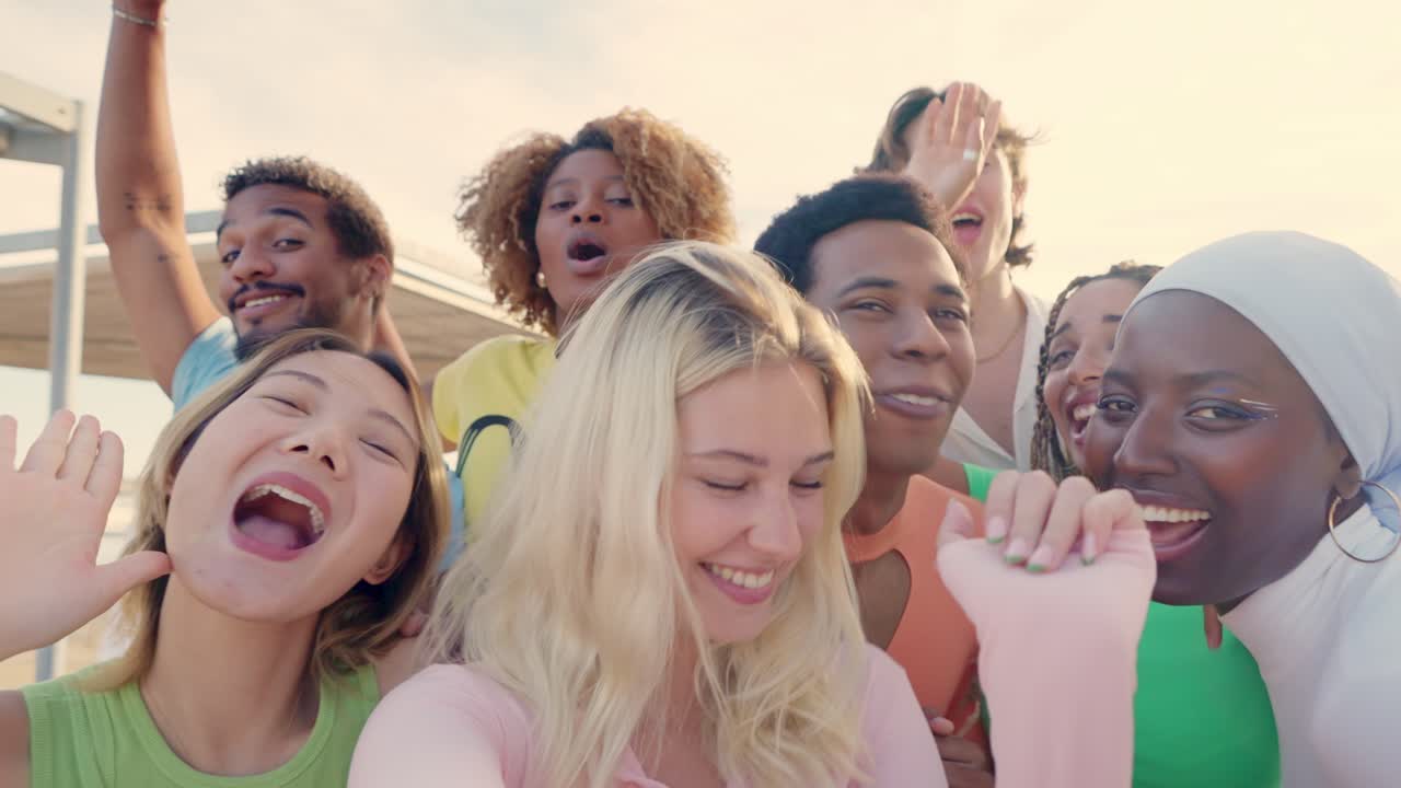 Happy blonde woman taking selfie with multi-ethnic friends outdoors