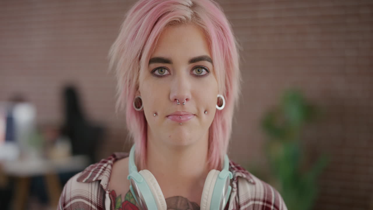 retrato de mujer joven independiente con cabello rosado con aspecto confiado estudiante de sexo femenino con piercings estilo de moda punk serie de personas reales