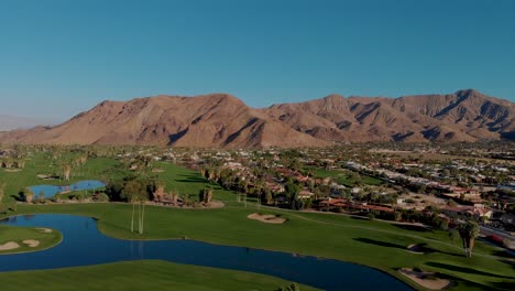 drone disparado tirando hacia atrás sobre palm springs campo de golf y barrio de lujo