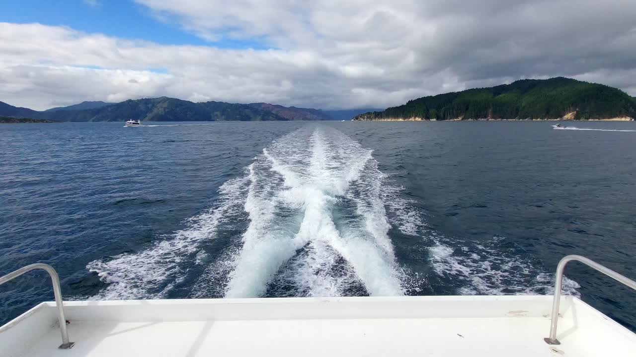la vista de la estela de un pequeño ferry que navega a través de los sonidos de marlborough en la isla sur de nueva zelanda