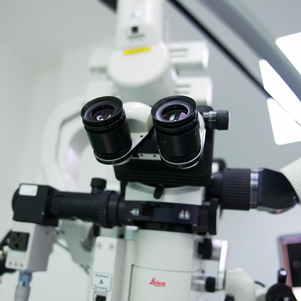 Binoculars of powerful advanced microscope hanging in the modern surgery room. Close up. Blurred background