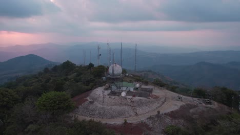 Orbital-drone-shot-of-a-radio-transmitter-on-a-hilltop-in-Cerro-Azul,-a-village-that-was-once-a-commercial-port-in-Cañete-Province,-Lima-Region,-Peru