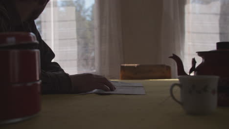 nervous man tapping his fingers on kitchen table, old retro interior