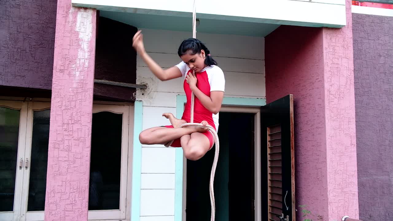 The scene from the front where the girl is doing different yoga poses on the rope without holding on to anything is amazing to watch