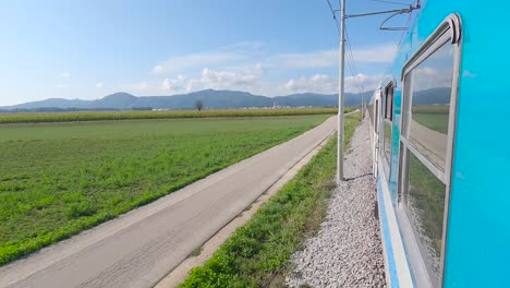 tren de pasajeros en eslovenia saliendo de ljubljana entre campos, cámara a bordo