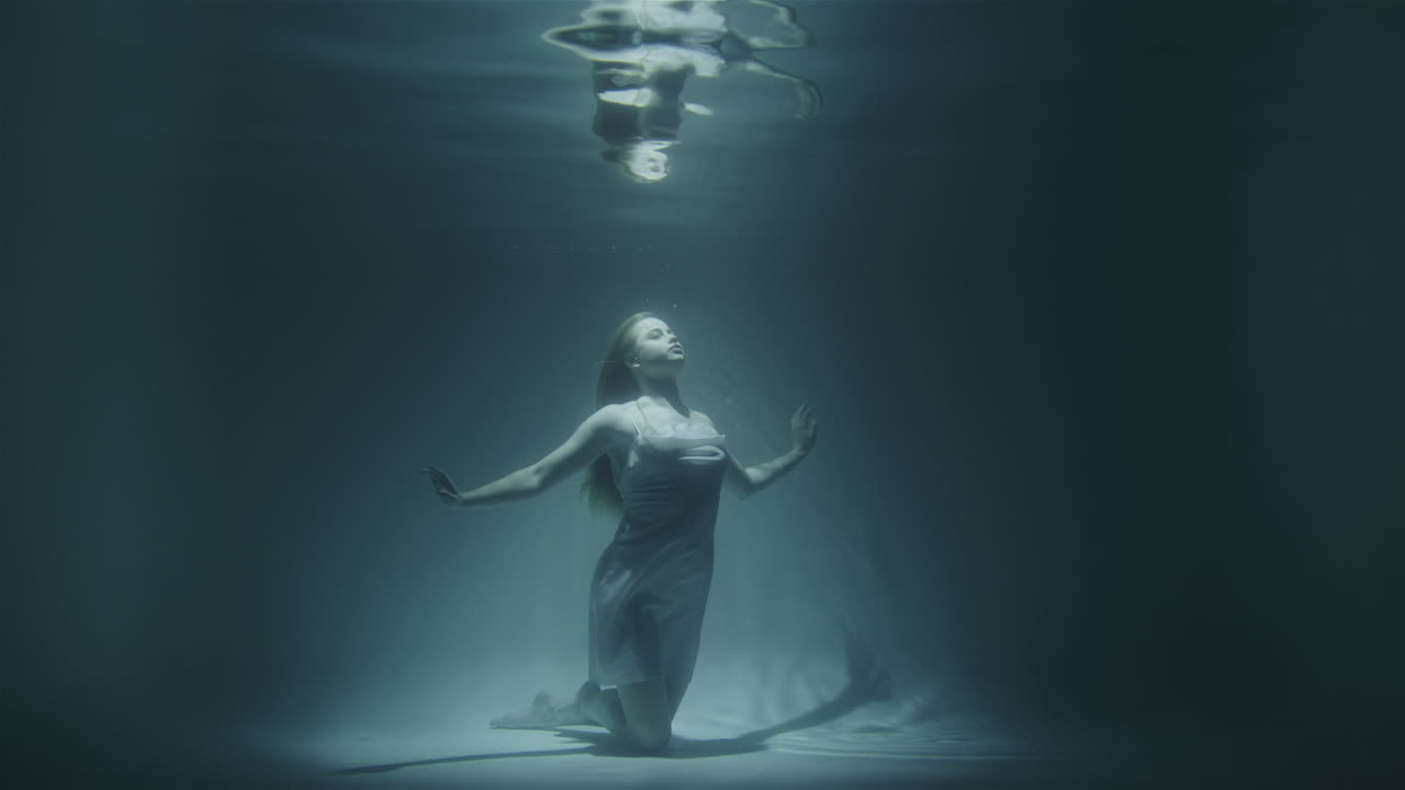 la chica se congeló bajo el agua en el fondo mirando hacia arriba