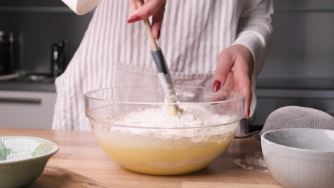 Panadero-Mezclando-Harina-En-Huevo-Y-Leche-En-Un-Recipiente-De-Vidrio-Usando-Una-Espátula-De-Silicona