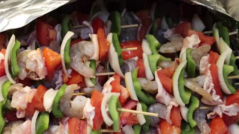 primer plano de brochetas de camarones cubiertas con papel de aluminio