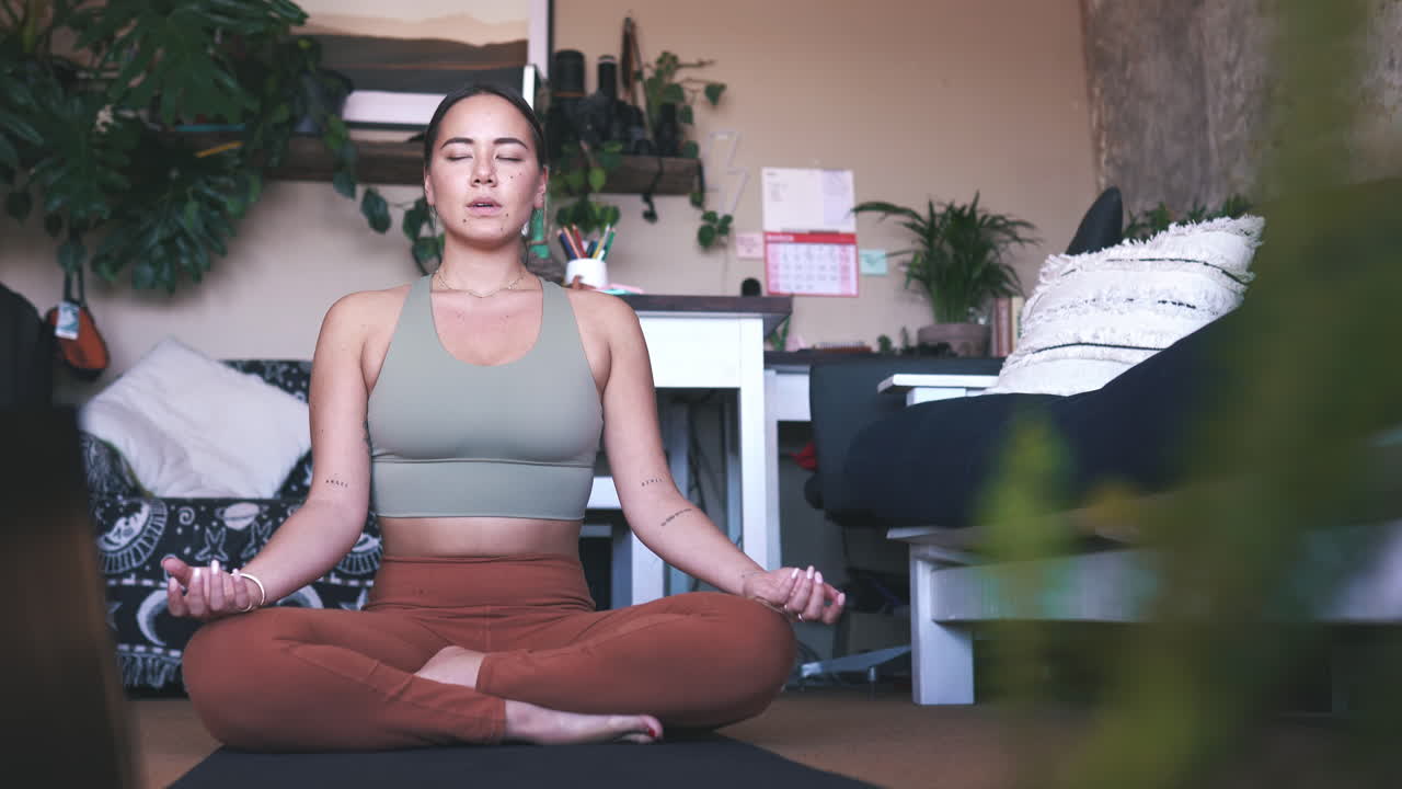 una mujer joven meditando en la sala de estar