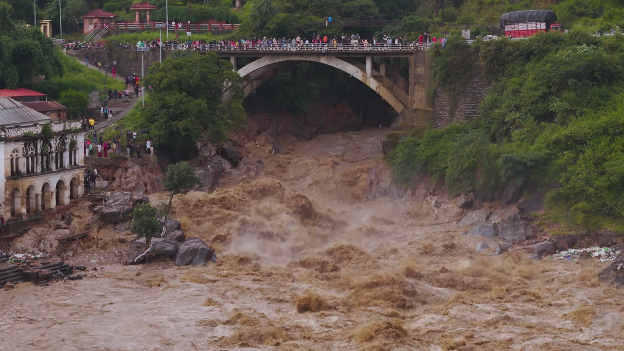 Drone shot of huge flood disaster in Kathmandu Nepal where Bagmati river causing alarming climate crisis and devastation to infrastructures, people come to rescue in river banks due to cloud brust